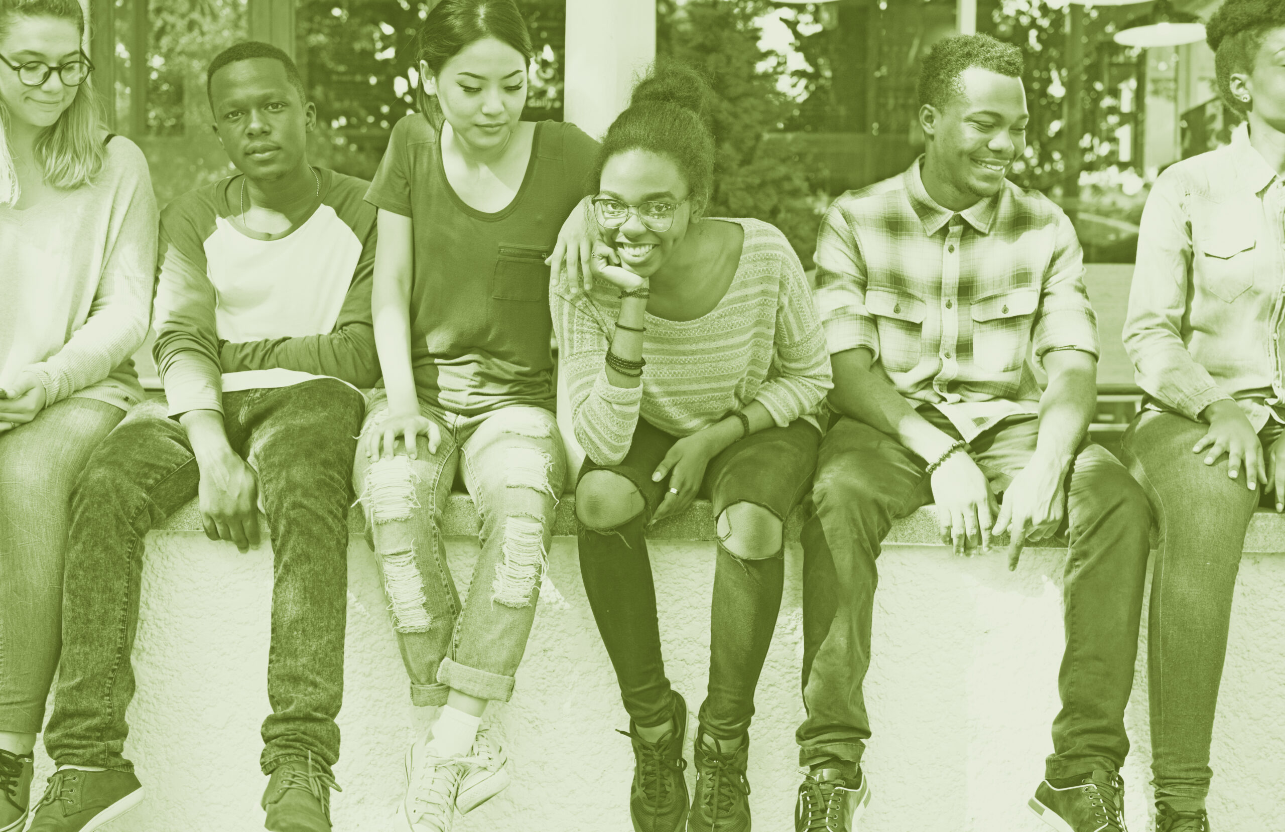 Youth mental health photo. A group of teenages sitting on a wall together.